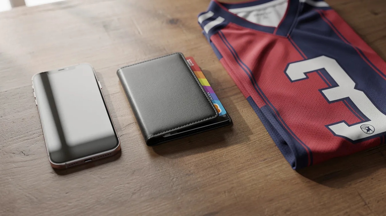 The image shows a wallet, a payment card, and a smartphone resting on a desk next to a sports jersey, suggesting a connection to sports betting and online sportsbook activities. The arrangement hints at an engaging betting experience for fans of sports like the Premier League and the Champions League.